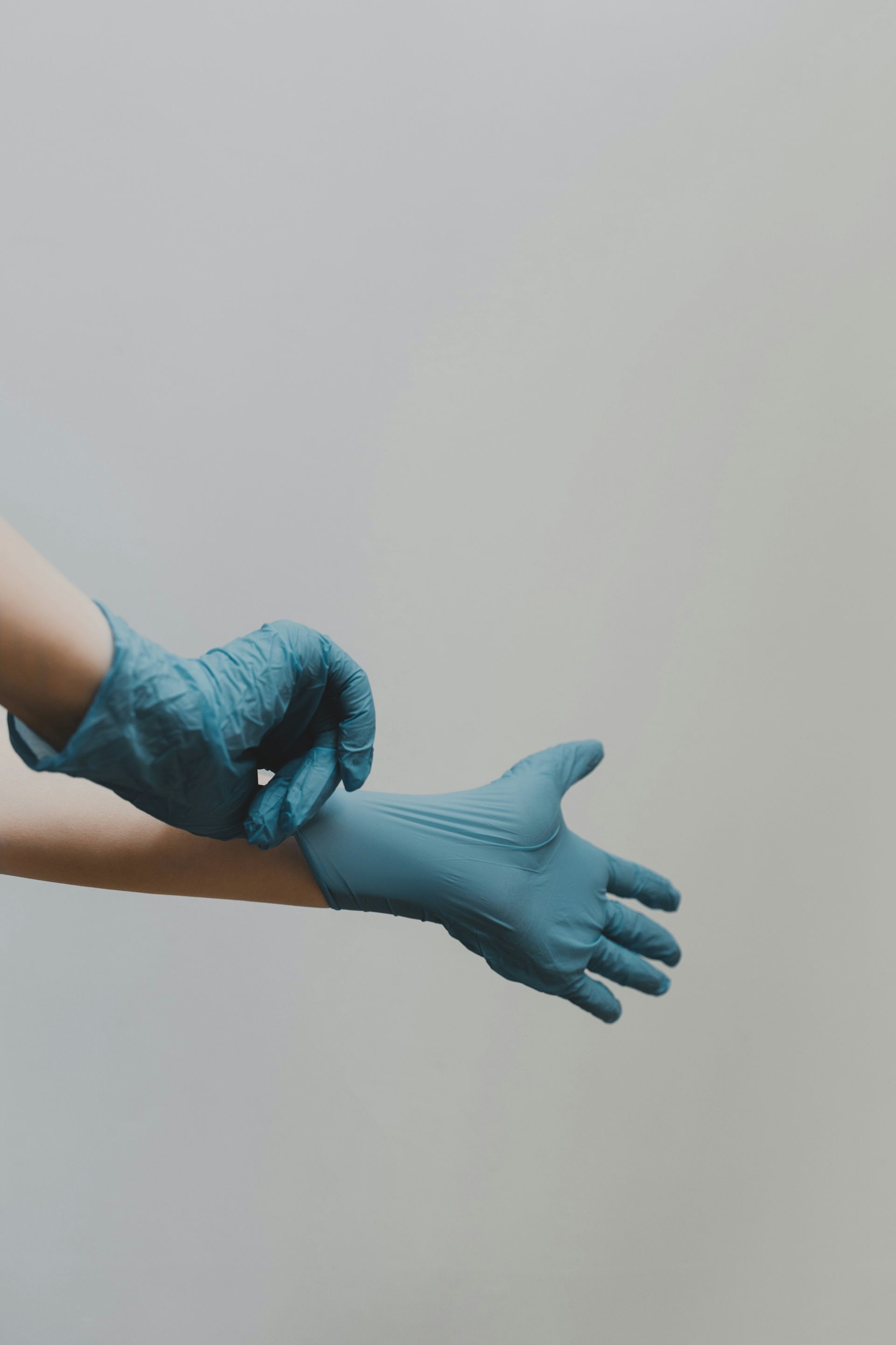 person putting on blue medical gloves